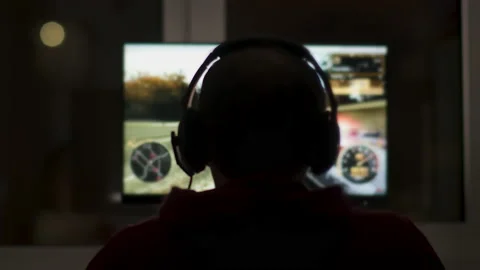 Rear view of a man playing at night in front of a computer monitor Stock Footage 150391730