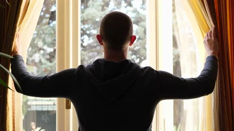 Rear View of a Man with Standing and Drawing the Curtains at Home, Quarantine Stock Footage 146606158