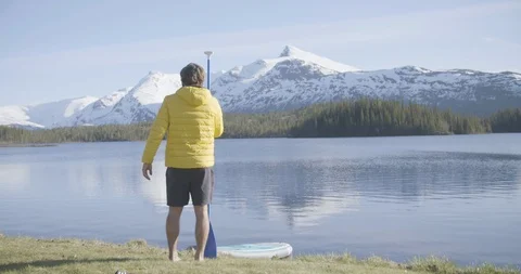 Rear view of man standing with oar near lakeshore Stock Footage 85842066
