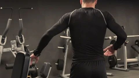 Rear view of man stretching back muscles and bending in gym Stock-Footage 101745651