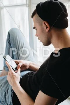 Rear view of man using cellphone Stock Photos