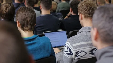 Rear view of a man using laptop at the conference Stock Footage 87955939