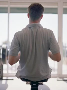 Rear view of man using rowing machine Stock Photos