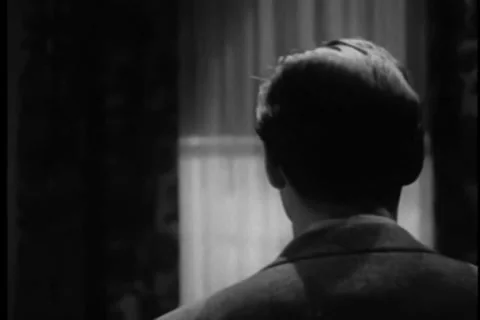 Rear view of man walking over to window and opening it, 1940s Stock Footage 35327985