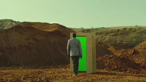 Rear view of man walking on red sand in front of the door with green screen Stock Footage 247261318