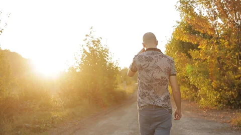 Rear view of man walking at sunset Stock Footage 116893068