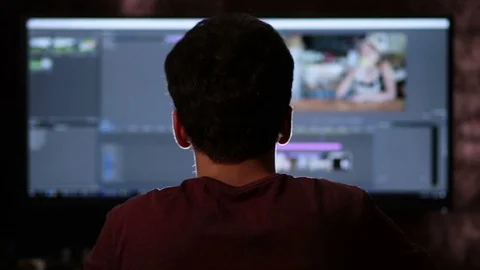Rear view of man working on wide screen computer Stock Footage