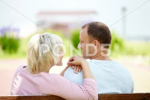 Rear view of a mature couple sitting on bench Stock Photos