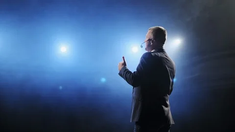 Rear view of men speaking through a microphone in dark conference hall. Man Stock Footage 121588762