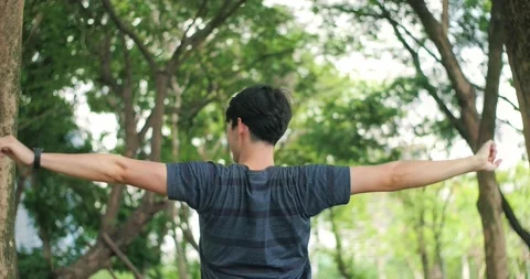 Rear view of men taking deep breath in the green park Stock Footage 153194368