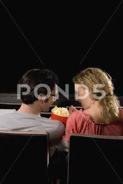 Rear view of a mid adult couple sitting in a movie theater Stock Photos