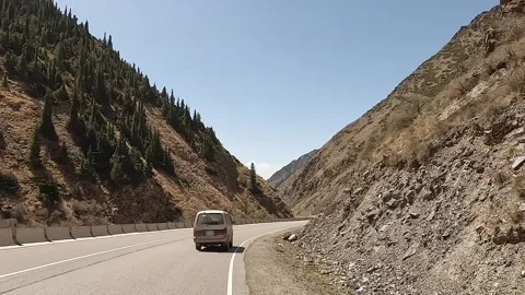 Rear view of a minivan driving along a beautiful mountain road Video stock 241381637