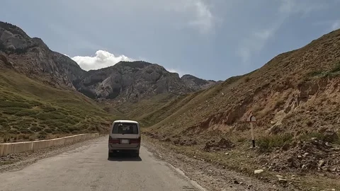 Rear view of a minivan driving through a beautiful mountain valley Stock Footage 241381402