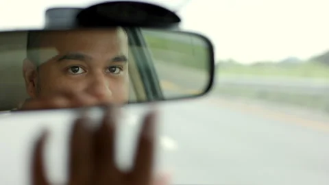 Rear view mirror. Close up shot eye of young asian man looking roadway while dri Stock Footage 161301720