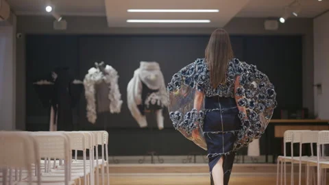 Rear view of a model wearing an avant garde dress featuring textured blue fabric Stock Footage 335349376