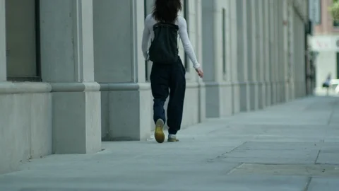 Rear view of modern man walking on sidewalk in city Stock Footage 107028607