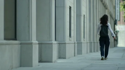 Rear view of modern man walking on sidewalk in city Stock Footage 107028679