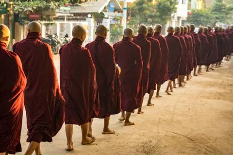 Rear view of monks in queue on street receiving alms, Nyaung U, Myanmar Stock Photos