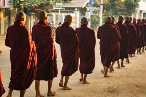 Rear view of monks in queue on street receiving alms, Nyaung U, Myanmar Stock Photos
