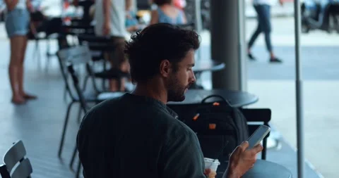 Rear view multi-ethnic attractive handsome young man, chilling in cafe, drinking Stock Footage 217991320