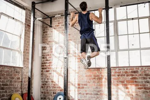 Rear view of muscular man doing pull ups Stock Photos