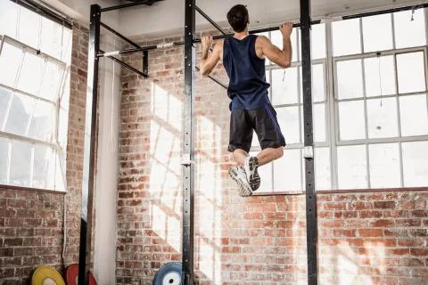 Rear view of muscular man doing pull ups Stock Photos