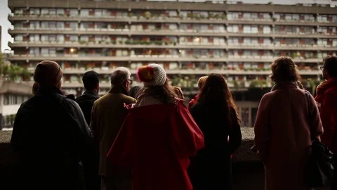 Rear view panning shot of group of people looking at city buildings Stock Footage 114841758