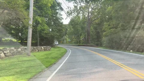 Rear View Perspective of Driving Down Country Road Past Forest and Houses Stock Footage 342082459
