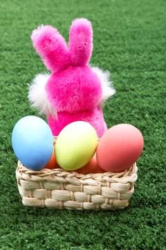 Rear view of pink bunny with easter eggs in basket Stock Photos