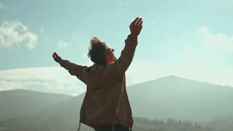 Rear view portrait happy inspired man traveler raising his arms into blue sky Stock Footage 166859685