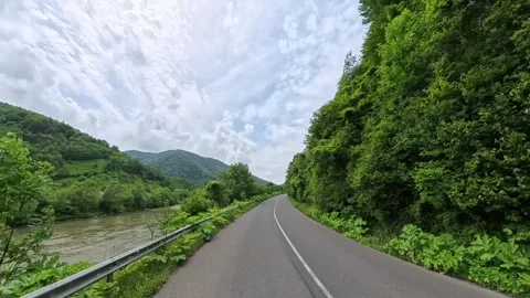 Rear view POV shot from a moving car showing a winding asphalt mountain road Vídeo Stock 346180936