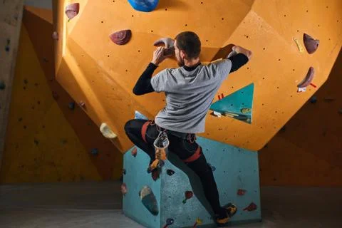 Rear view of powerful physically challenged boulderer climbing at rock wall Stock Photos