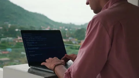 Rear view of programmer developer programmer freelancer writes code at a laptop Stock Footage 192841317