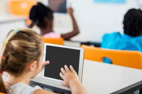 Rear view of pupil using tablet pc in classroom Stock Photos