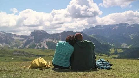 Rear view of romantic couple sitting on alpine meadow in the Dolomites with Stock Footage 318665387