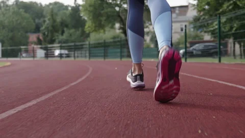 Rear view of runner legs jogging on a stadium running track Stock Footage 346533298