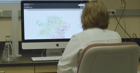 Rear view of scientist checking molecular model on computer Stock Footage 104340452