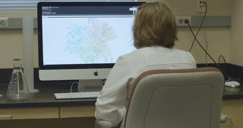 Rear view of scientist checking molecular model on computer Stock Footage 104341465
