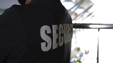 Rear view of security guard in uniform patrolling in commercial mall Stock Footage 153799758