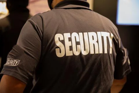 Rear view of security guard in uniform patrolling in commercial mall Stock Photos