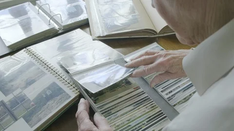 Rear view of a senior man looking through old photo albums Stock Footage 104583667