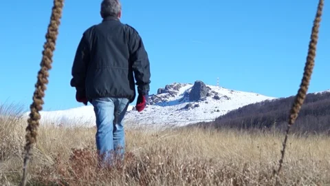 A rear view of a senior man walking in a mountain area. Stock Footage 129191830