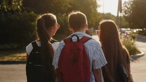 Rear view of a shoolchildren walk down the street Vidéo 139401928