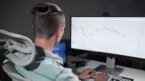 Rear view shot of a computer programmer stretching in his chair working late Stock Footage 115534971