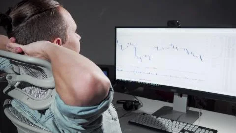 Rear view shot of a computer programmer stretching in his chair working late Stock Photos
