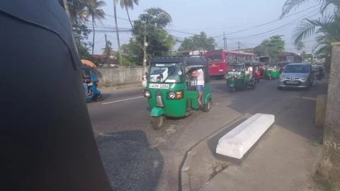 A rear-view shot from a moving tuk-tuk in Sri Lanka, showing a line of tuk-tuks Stock Footage 303559909