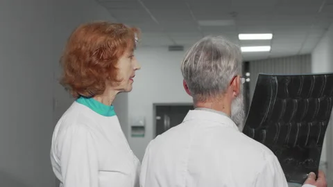 Rear view shot of two elderly doctors examining MRI scan together Stock Footage 137258996