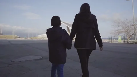 Rear view of a single mother walking with her son holding hands. Stock Footage 149054991