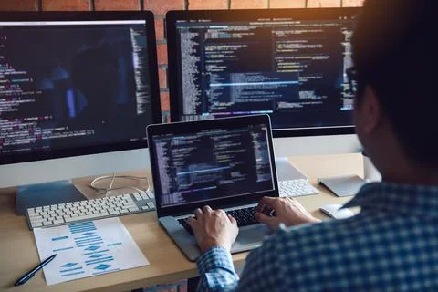 Rear view of software developers is sitting serious analyzing data on the c.. 库存照片