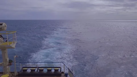 Rear view from stern of moving cargo ship navigating deep blue ocean Stock Footage 346263082